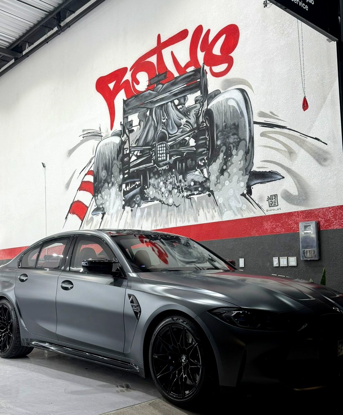 BMW M3 detalhado na Roth's, em frente ao mural da oficina