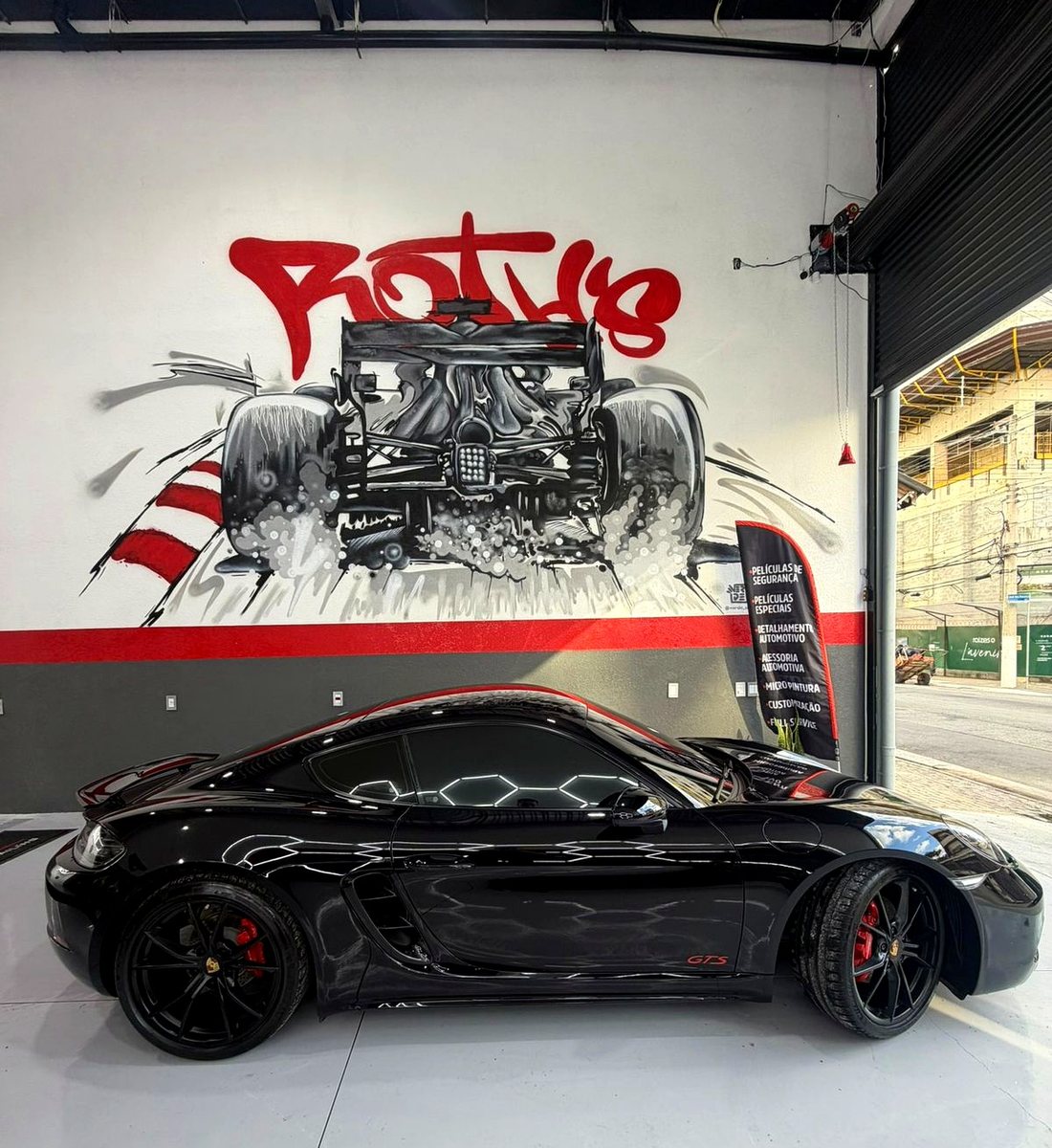 Porsche 718 GTS detalhado na Roth's, em frente ao mural da oficina